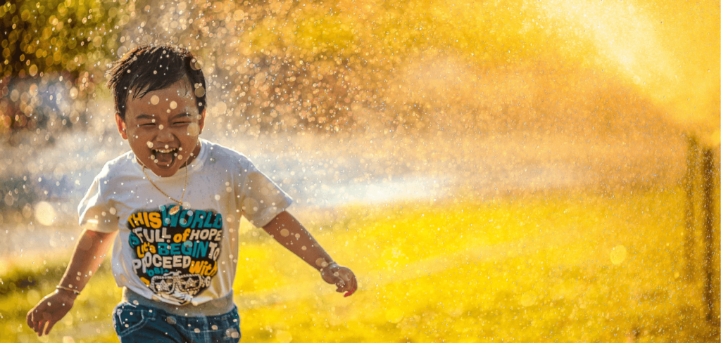 Kid playing in sprinkle water. 